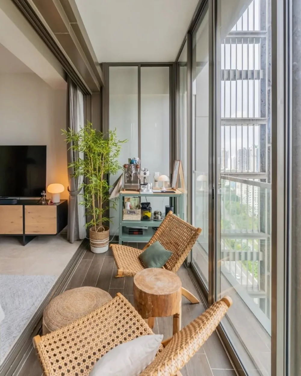 enclosed balcony with wicker chairs, wood accents, and city views